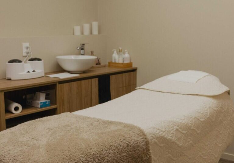 Cozy massage room with a treatment table.